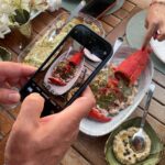 Denizevi Karvunyi’de taze ıstakoz sunumu ve misafirin yemek fotoğrafı çekerken yakalanan anı – Marmara Adası’nda gastronomi deneyimi
